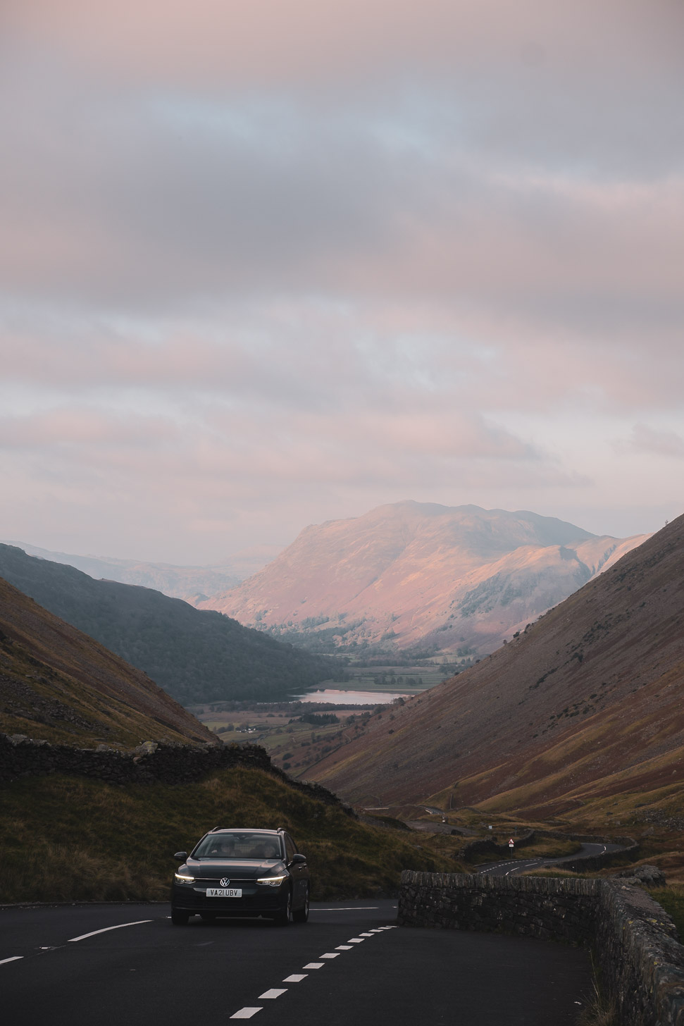 Car driving over pass in Lake District