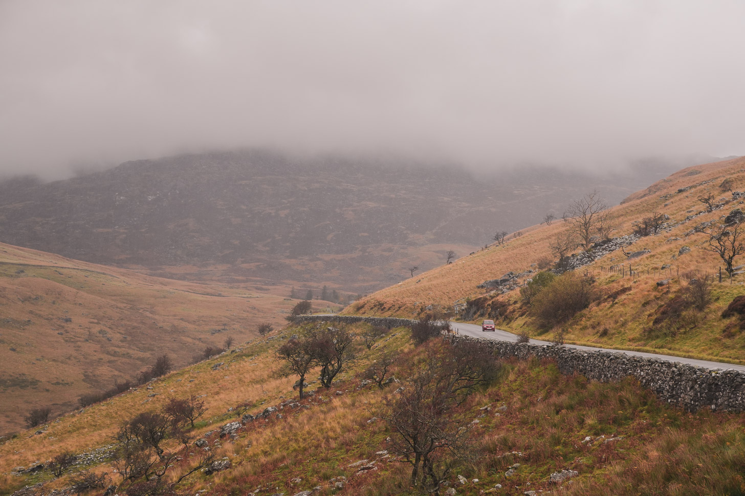 Car driving over mountain pass in Wales